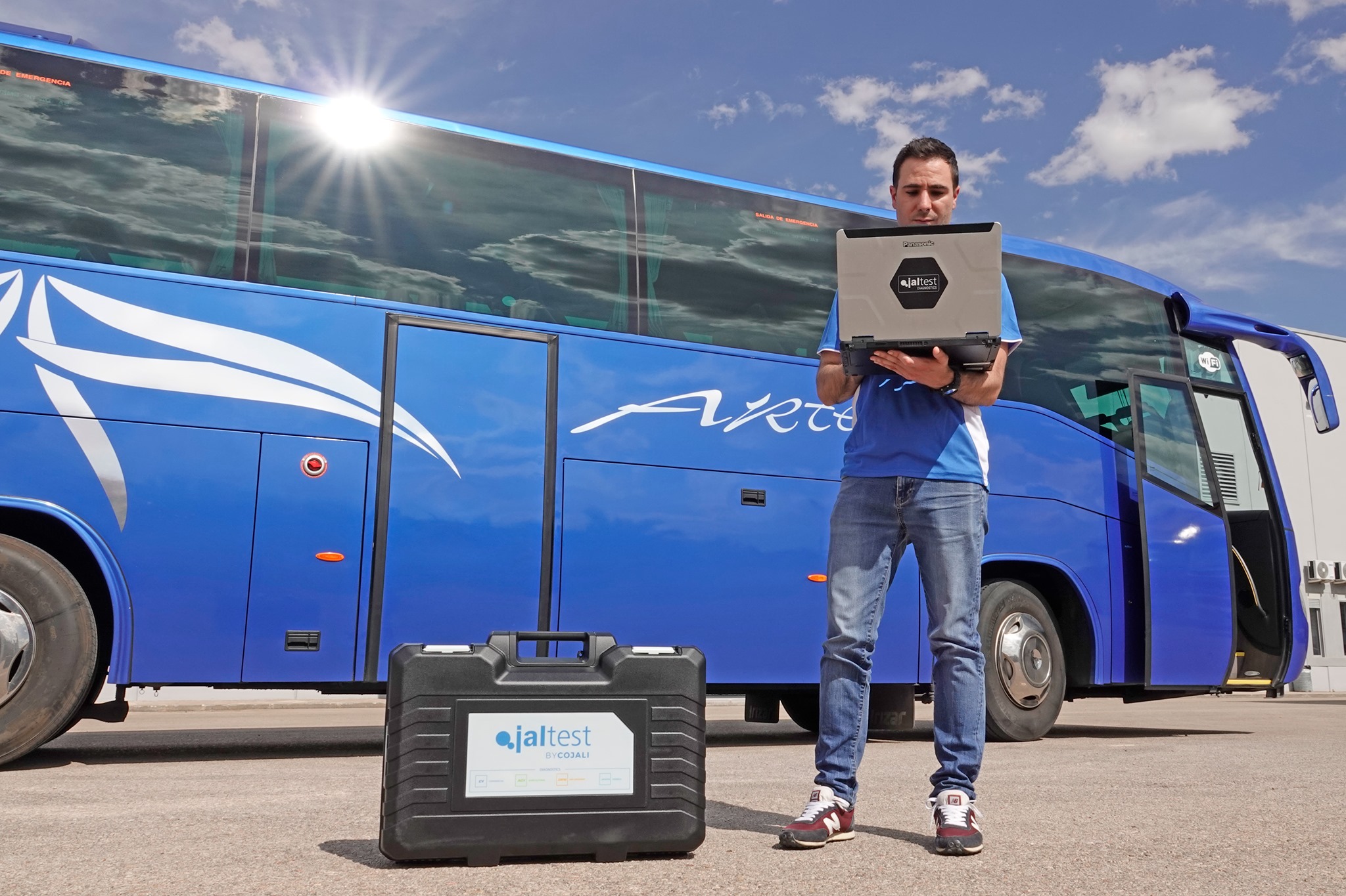 Man stood next to blue bus with Jaltest diagnostics laptop.