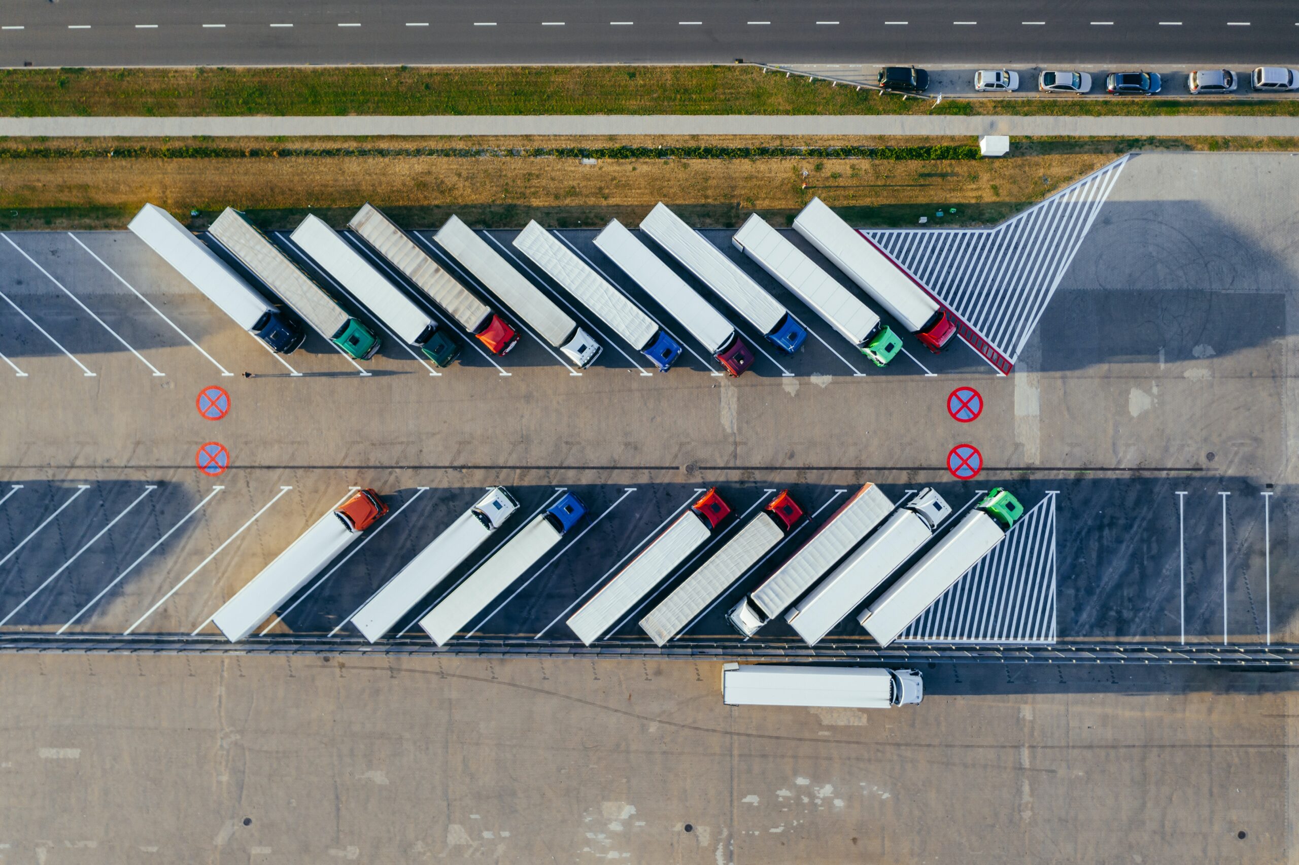 Birdseye view of a fleet of lorries parked in a car park.
